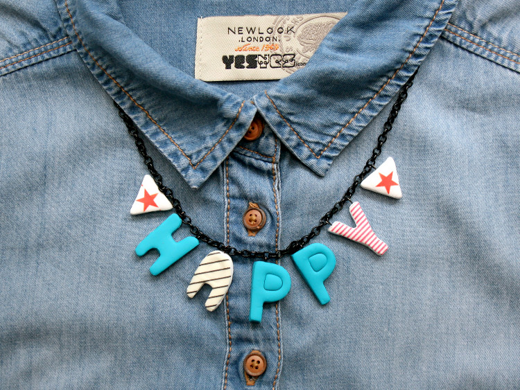 Alphabet necklace worn with a denim shirt