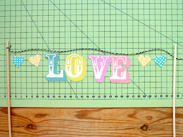 Attaching the letters and hearts to the bakers twine