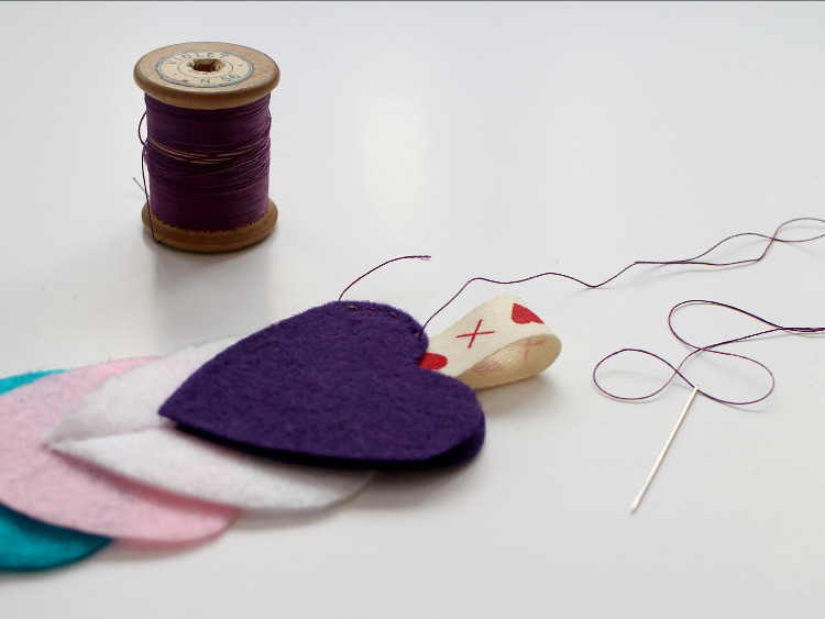 Stitching the felt hearts and ribbon in place