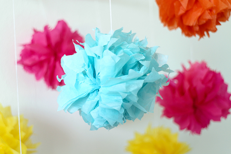 Bright colours work well for a cheerful paper pom pom mobile